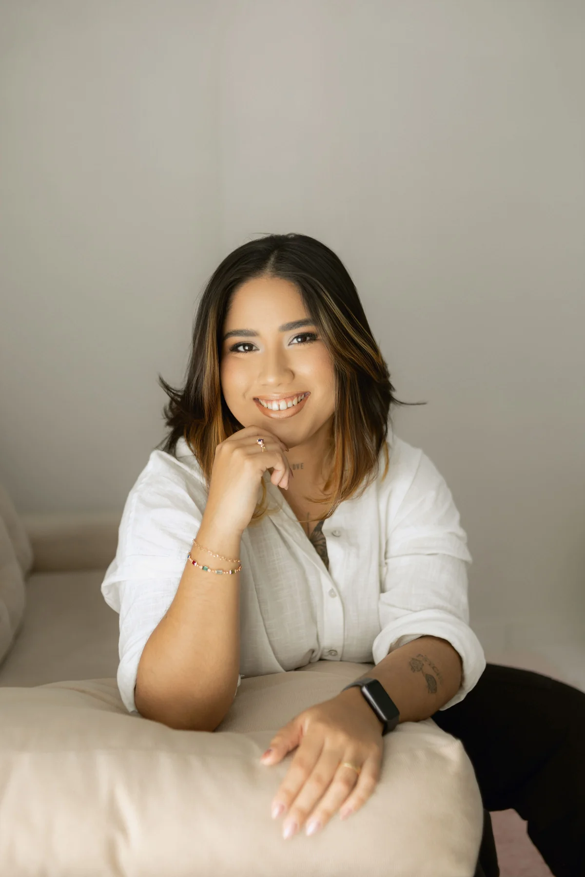 Lydhia Lins sorrindo, sentada no sofá do consultório